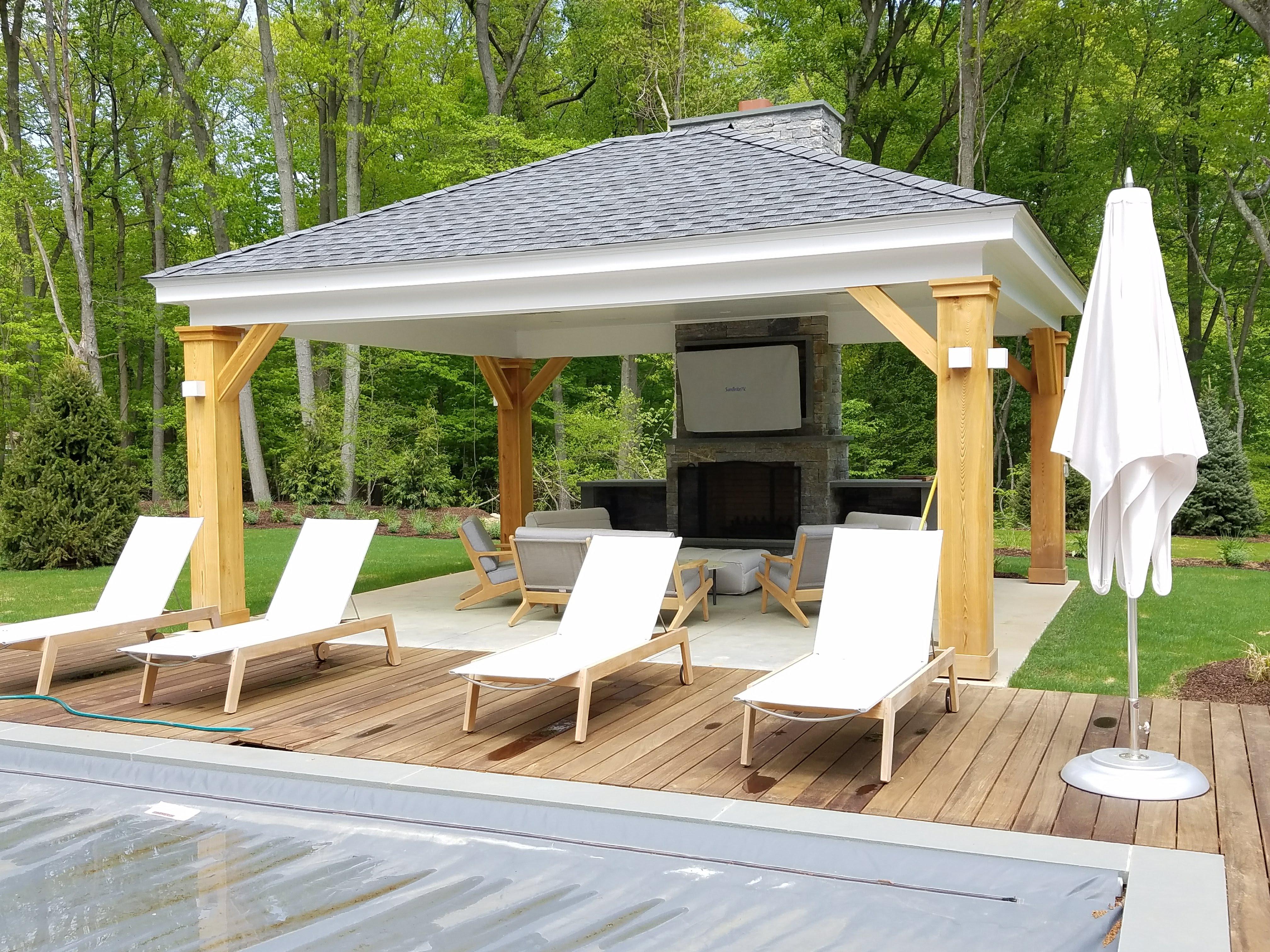 outdoor pool area with covered seating and fireplace