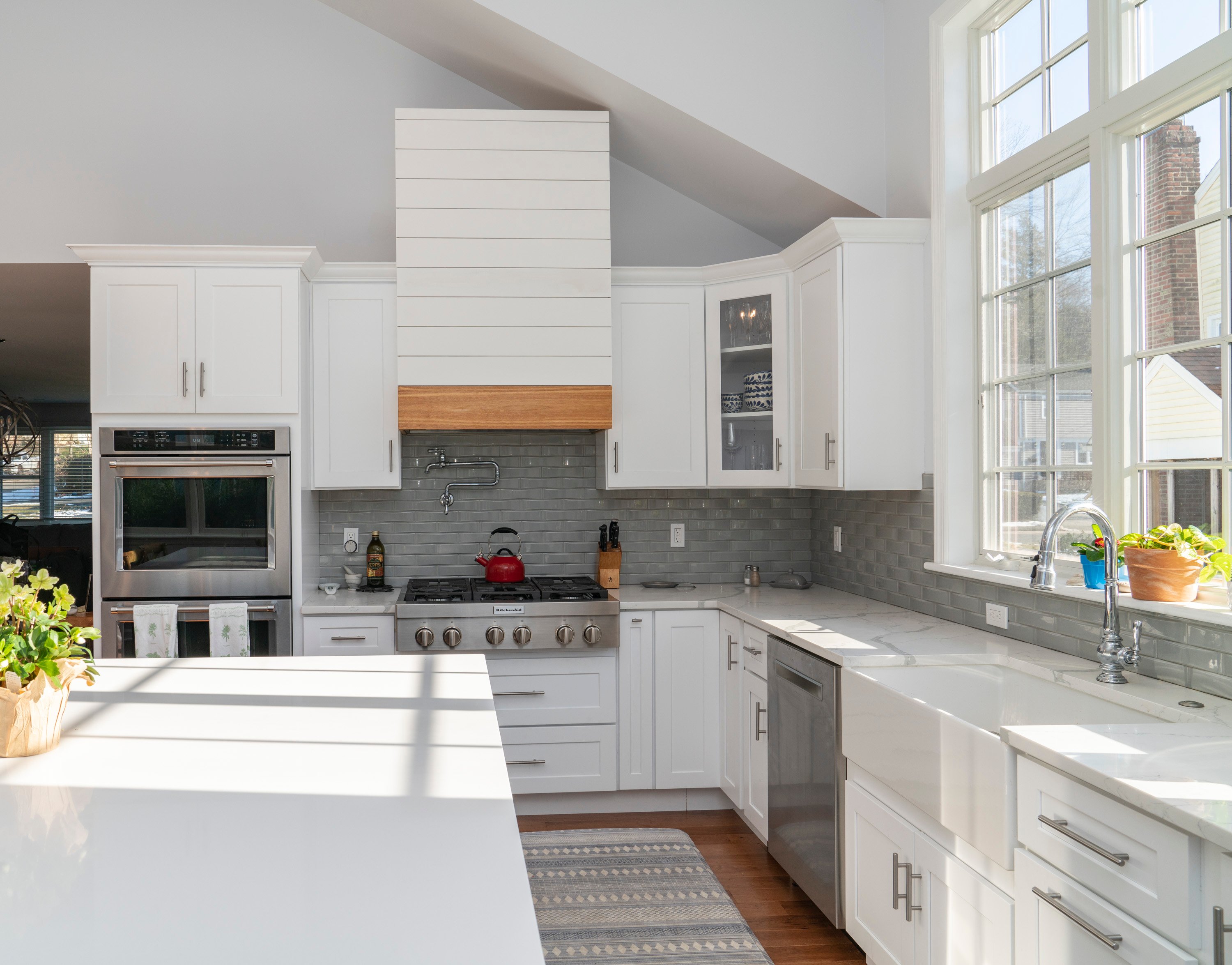 grey backsplash in white kitchen with large window over sink