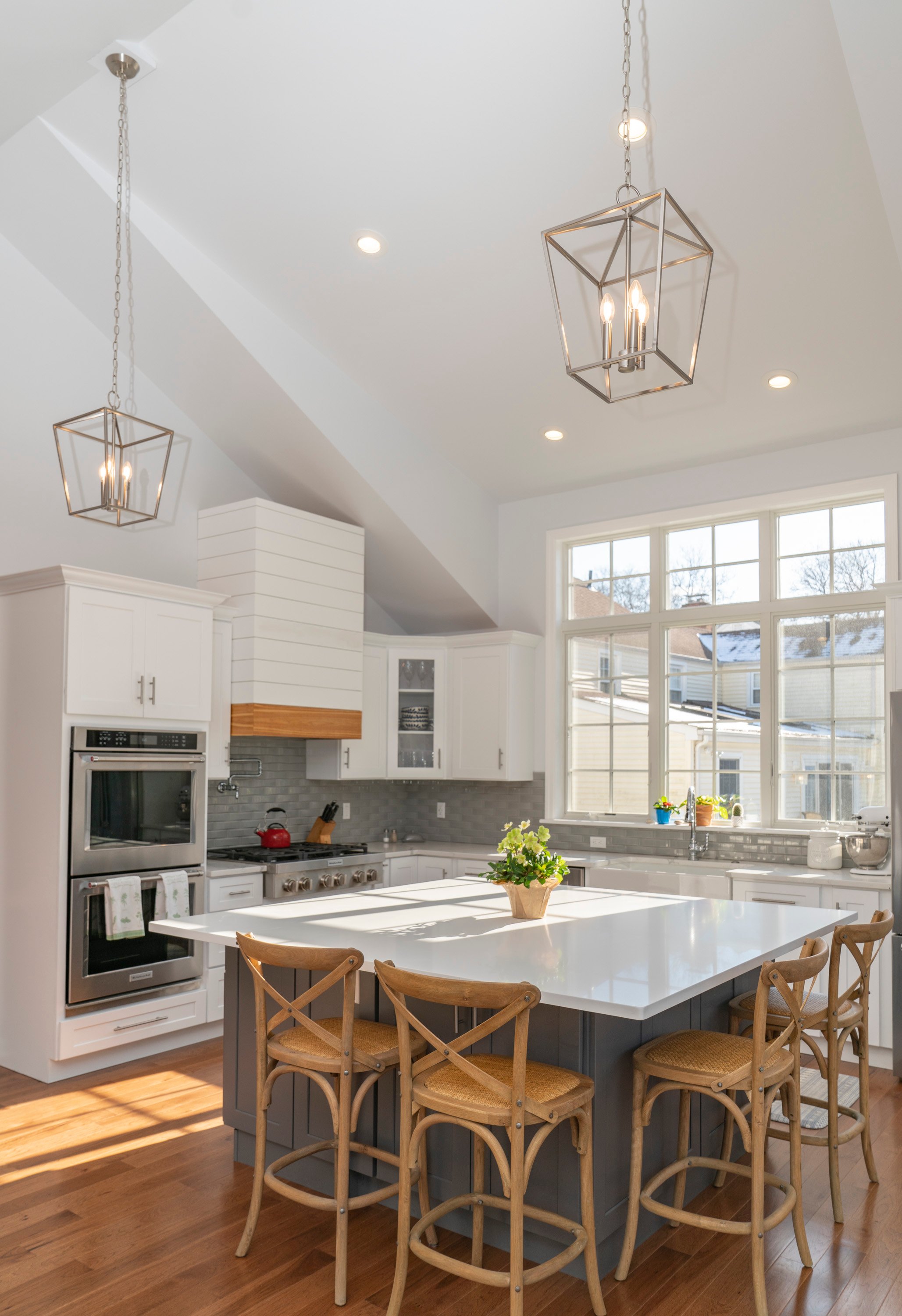 white kitchen with grey island and 2 rectangle light fixtures
