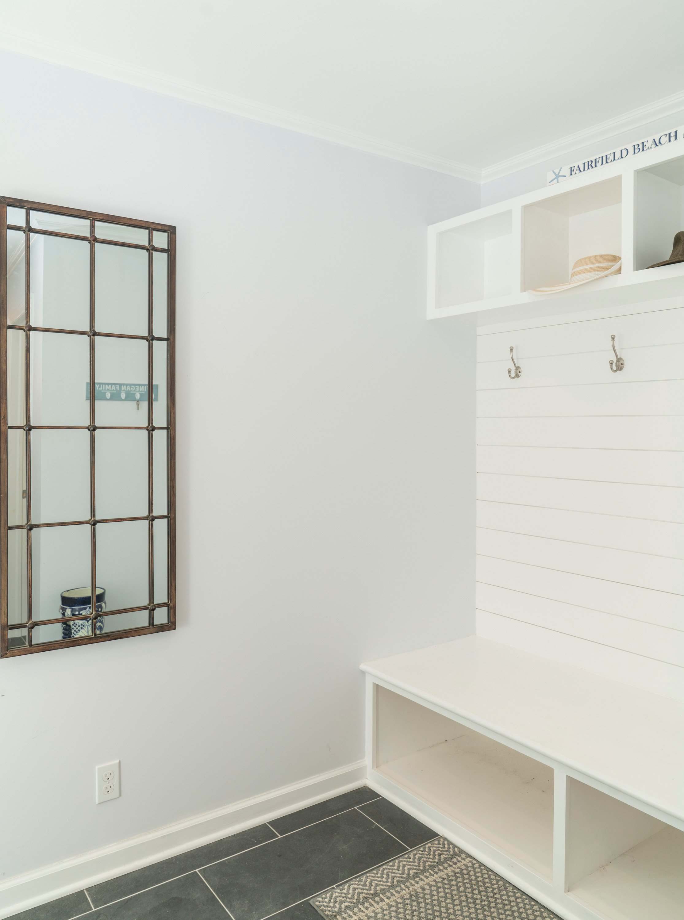 mudroom with while walls and built in shelving