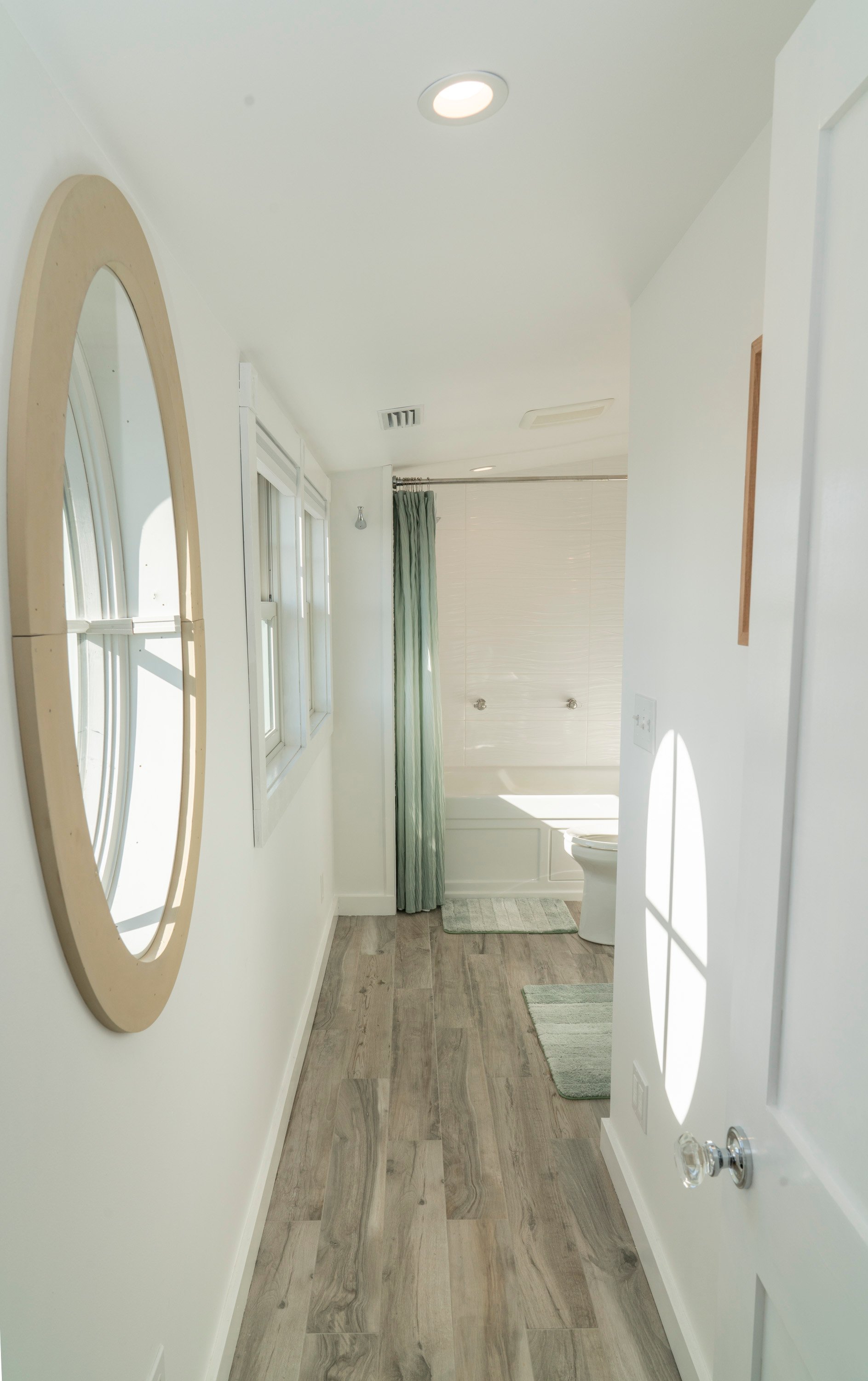 round window in bathroom with light wooden flooring