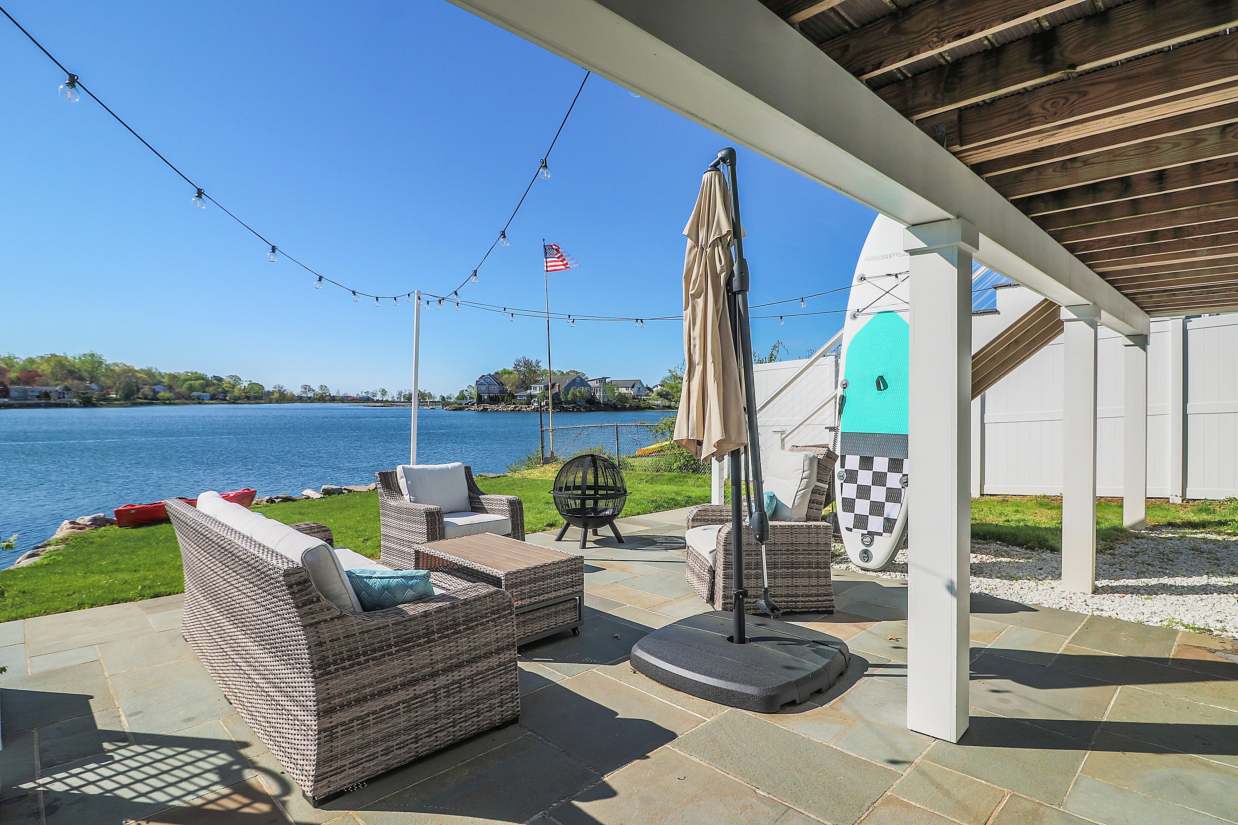 outdoor seating on stone patio overlooking lake view