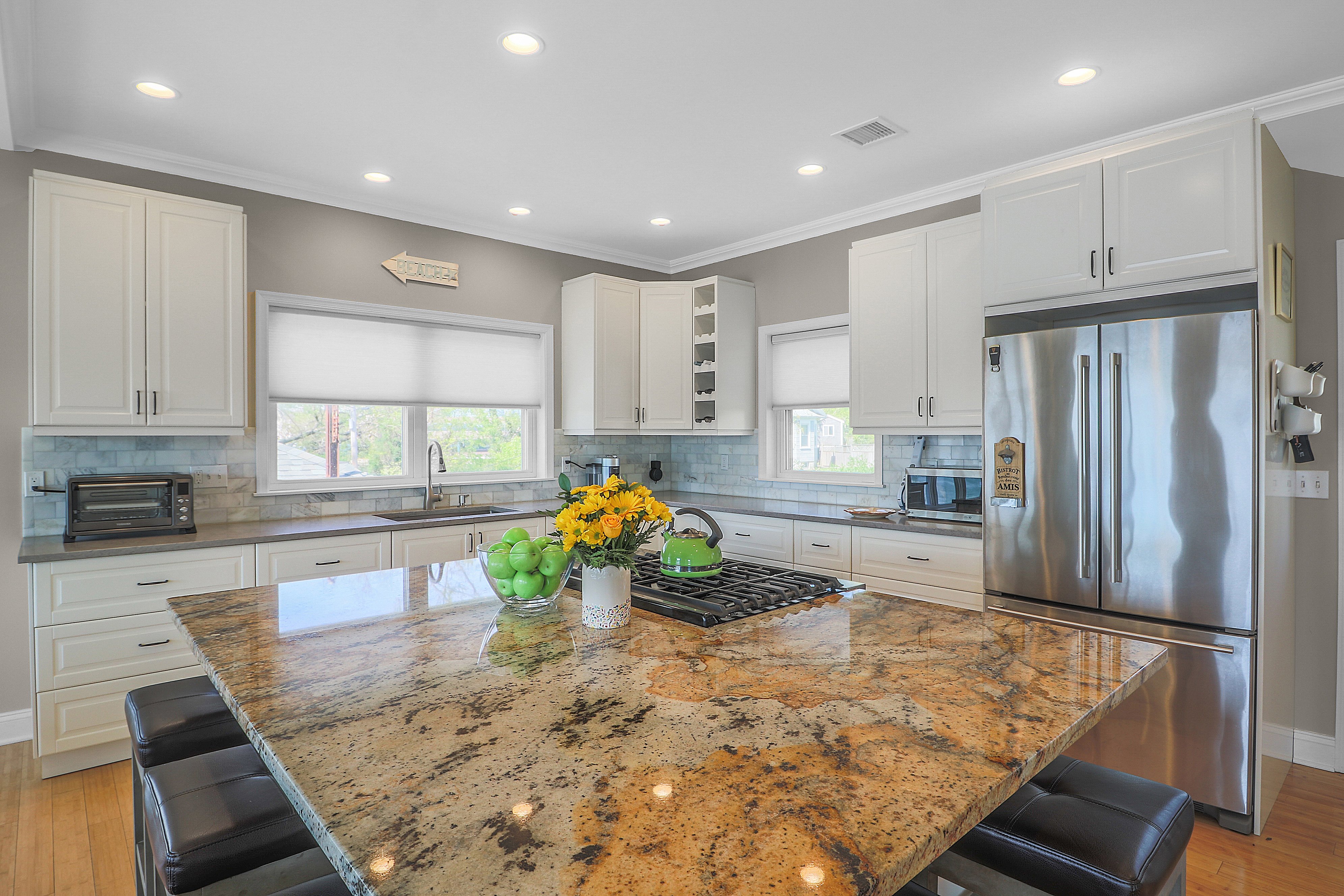kitchen with brown granite square kitchen island and black bar stools 